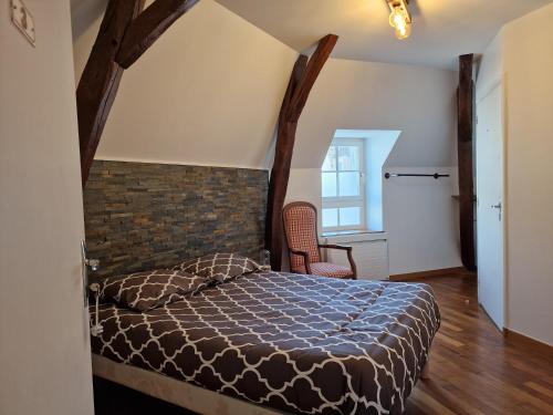 a bedroom with a bed and a brick wall at Les Chambres de Beaumont in Beaumont-Village