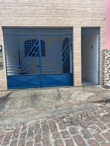 un garaje con una puerta azul y un edificio en Casa de Guinho, en São Félix