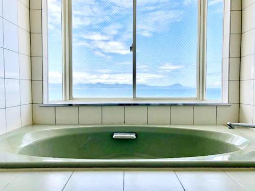 a bath tub in a bathroom with a window at Umi no Gohanya Noramare - Vacation STAY 18191v in Masuda