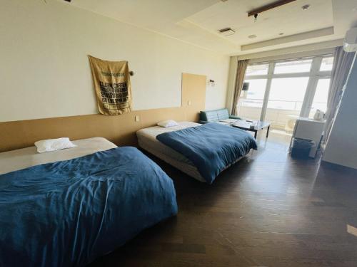 a hotel room with two beds and a chair at Umi no Gohanya Noramare - Vacation STAY 18191v in Masuda