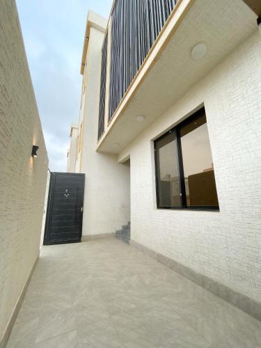 a walkway leading to a building with a black door at نزل الراشد الفاخرة luxury in Abha
