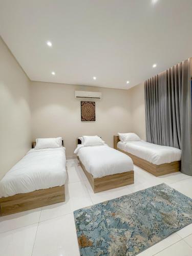 a bedroom with two beds and a rug at نزل الراشد الفاخرة luxury in Abha