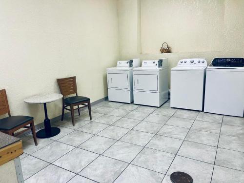 a room with two washing machines and a table and chairs at Baymont by Wyndham Keokuk in Keokuk