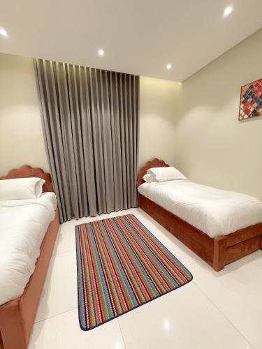 a bedroom with two beds and a rug at نزل الراشد الفاخرة luxury in Abha
