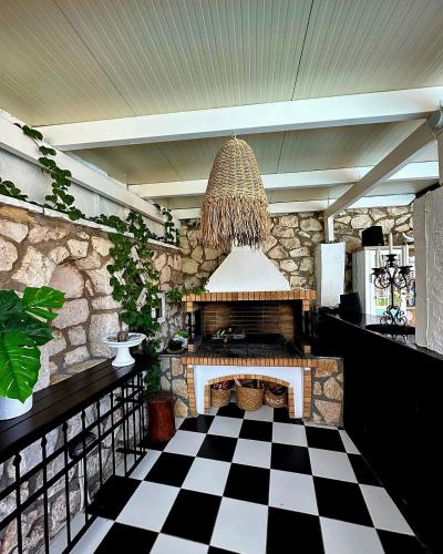 a living room with a fireplace and a checkered floor at Luxury Villa Athina in Nikiana