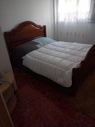 a bed with a wooden frame in a bedroom at T4 Prado vélodrome plage 3 chambres in Marseille