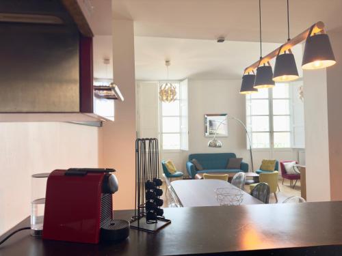 uma cozinha com uma mesa e uma sala de estar em L'annexe Bordeaux Traditions em Bordeaux