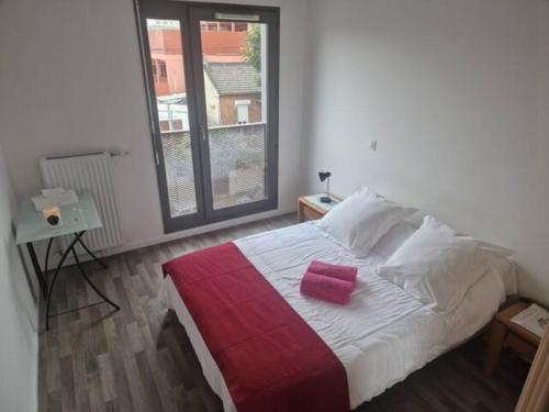 a bedroom with a bed with a pink pillow on it at Chambre Double a proximité de Paris in Saint-Denis