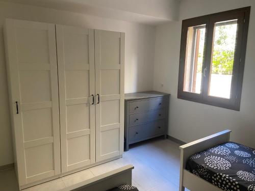 a bedroom with white cabinets and a bed and a window at Fort Chambray, Blissful Escape in Għajnsielem