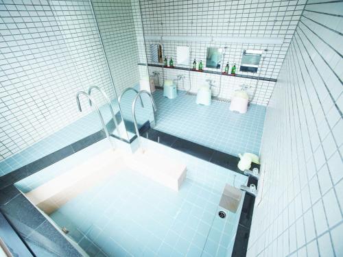 baño de azulejos azules con bañera y lavamanos en HOTEL MARINEPIA - Vacation STAY 92243v en Shinkamigoto