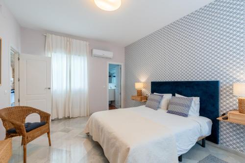 een slaapkamer met een groot bed en een stoel bij AtGr Luminoso Ático con Terraza, Calle Antonia Diaz in Sevilla