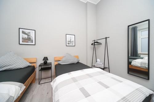 ein Schlafzimmer mit zwei Betten und einem Spiegel in der Unterkunft Apartment Central 85B 40qm Wi-Fi free in Dortmund