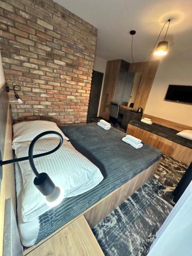 a bed in a room with a brick wall at Baltic Sun SPA in Rewal