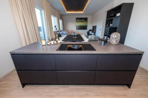 a large black island in a kitchen with a stove at Luxury stylish apartment central Akureyri in Akureyri