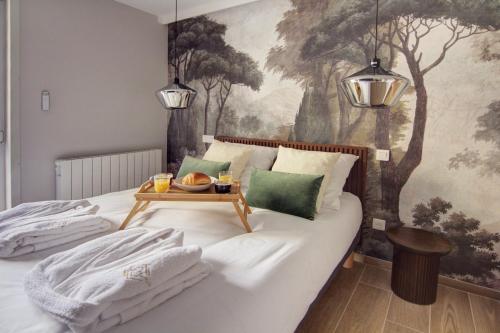 a bedroom with a bed with a tray of food on it at La Suite Rosièroise in Rosières
