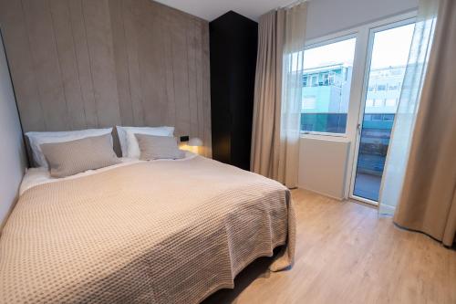 a bedroom with a large bed and a large window at Luxury stylish apartment central Akureyri in Akureyri