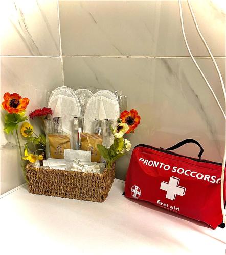 a basket of medicines and flowers next to a red bag at Appartamento Benaco 98 mq a Milano - Fondazione Prada in Milan