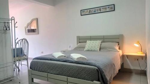 1 dormitorio con 1 cama con 2 toallas en Acogedor Monoambiente en Tarija, en Tarija