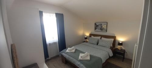 Un dormitorio con una cama con dos pañuelos blancos. en Apartment Lenchy en Zagreb