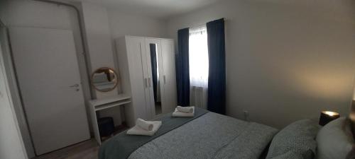 a bedroom with a bed with two white towels on it at Apartment Lenchy in Zagreb