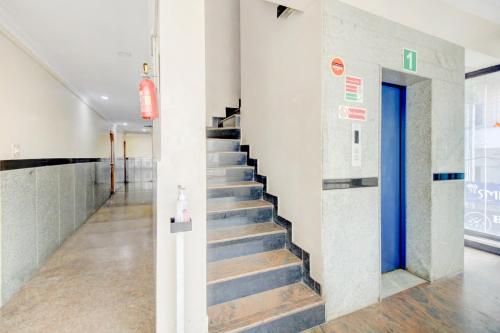 a staircase in a building with blue doors at OYO Hotel Vijay Residency in Bangalore