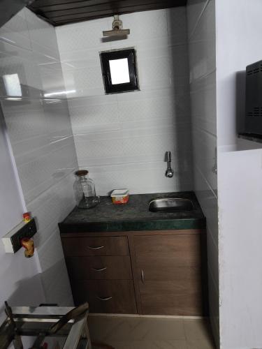 a small bathroom with a sink and a window at HOUSE 101 in Mumbai