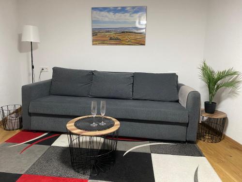 a living room with a couch and two wine glasses at Ferienstüble im Zabergäu- Ferienwohnung in Brackenheim