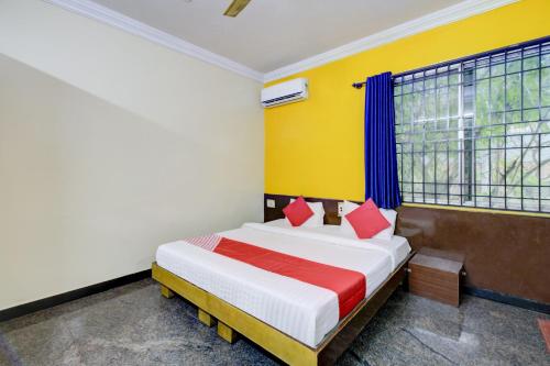 a bedroom with a bed with red and white pillows at OYO Hotel Vijay Residency in Bangalore
