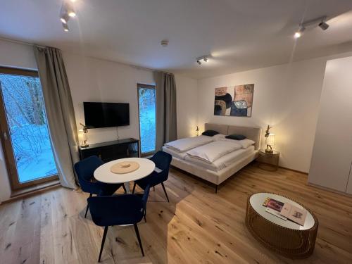 a bedroom with a bed and a table and chairs at Golden Ridge Apartments in Špindlerův Mlýn