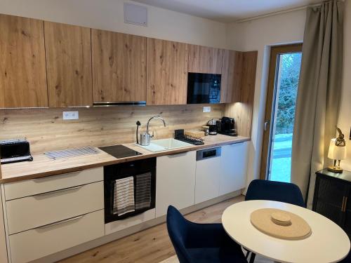 a kitchen with a sink and a table and a counter at Golden Ridge Apartments in Špindlerův Mlýn