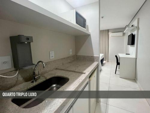 a kitchen with a sink and a counter top at Nox Apart Hotel - Garvey in Brasilia