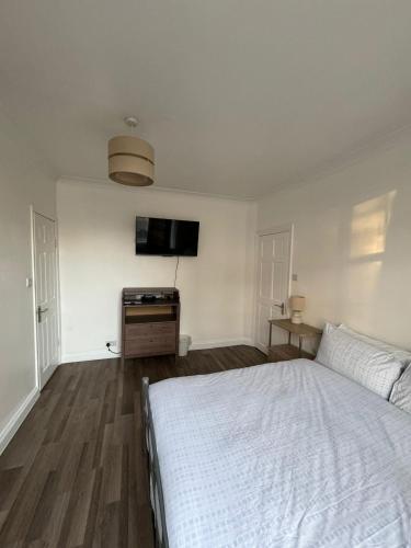 a bedroom with a white bed and a flat screen tv at Oxborne Rooms UK - Gardner in London
