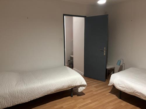 - une chambre avec 2 lits et un placard avec une porte dans l'établissement Gîte Vauban, à Saint-Omer