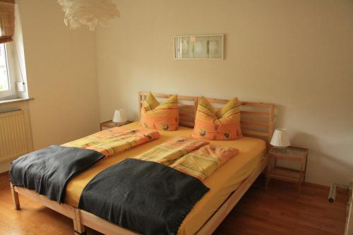 a bedroom with two beds with orange pillows at Ferienwohnung kleines Lautertal in Herrlingen