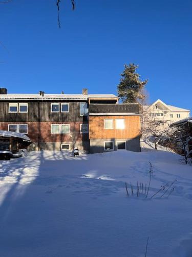 a snow covered parking lot in front of a building at Large house with beds for 12-14 in Trondheim