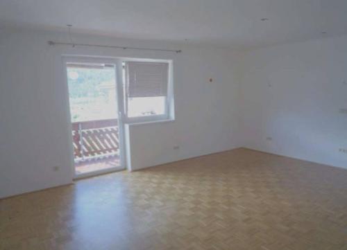 an empty room with a large window and a wooden floor at Helle Wohnung mit modernen Flair in Steinfeld
