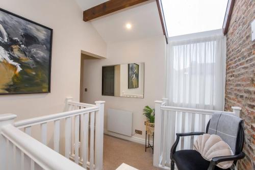 a white staircase with a chair and a painting on the wall at The Mitchell in York