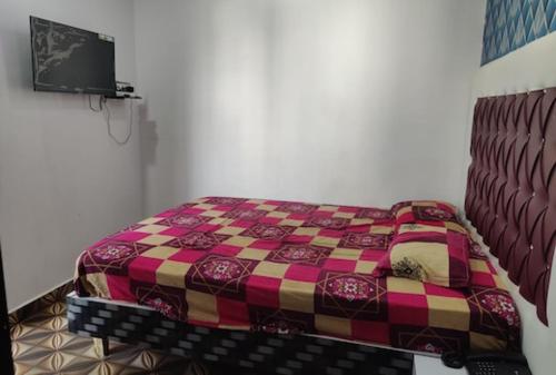 a bedroom with a bed with a colorful blanket at Hotel Shivaay Inn in Patna