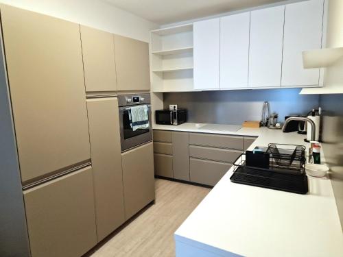 a kitchen with white appliances and white cabinets at Elegant Urban Residence with parking spot in Nivy