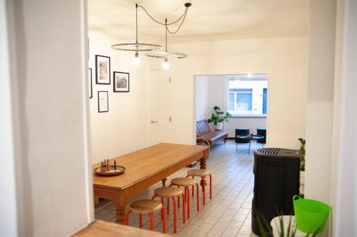 a kitchen and dining room with a wooden table and stools at Gaston vakantiehuis in Geraardsbergen