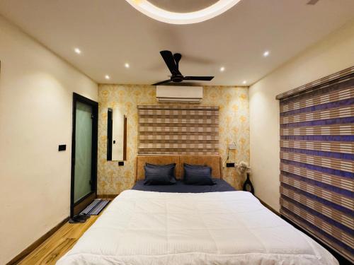 a bedroom with a bed and a ceiling fan at Home Escape Luxe 2BHK Penthouse Near LIG Square in Indore