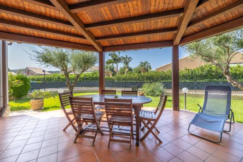 a patio with a table and chairs under a wooden pergola at Arvilla's Houses in Campofelice di Roccella