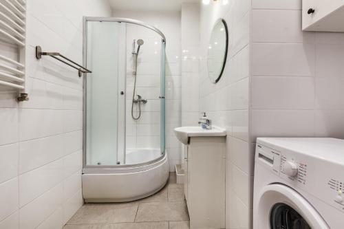 y baño con ducha, lavabo y lavadora. en Prime Home CENTRUM 2, en Gdynia