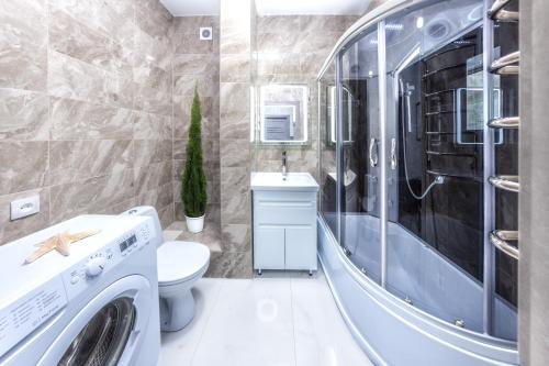 een wasruimte met een wasmachine en droger in de badkamer bij Европейская Пассаж ЦУМ in Dnipro