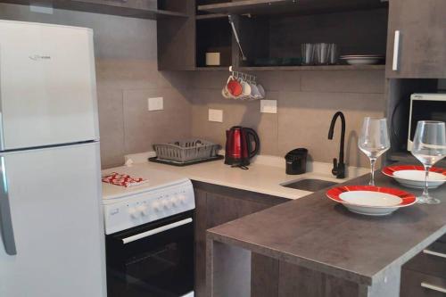 a kitchen with a white refrigerator and a stove at Exclusivo Monoambiente Moderno by G&A Rent (409) in Ezeiza