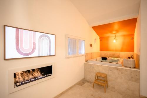 uma sala de estar com lareira e banheira em Nuits d'Audace em Alès