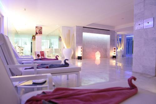 a large room with white chairs and a fireplace at Cesar Resort & Spa in Marrakech