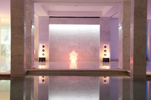 a room with a pool of water with a fireplace at Cesar Resort & Spa in Marrakech
