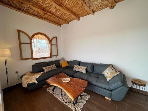 a living room with a blue couch and a wooden table at Le petit Chalet. in Essaouira