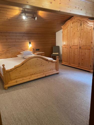 a bedroom with a large wooden bed in a room at Haus Bitschnau in Klösterle